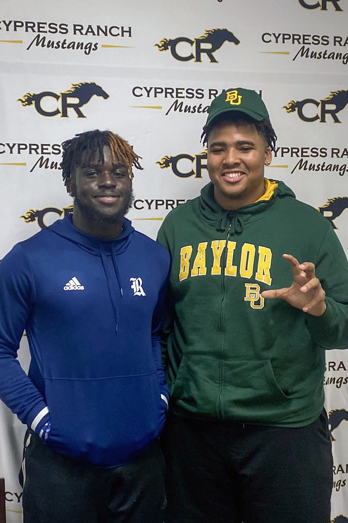 Cypress Ranch High School seniors Chibi Nwajuaku, left, and Bryce Simpson smile after signing their letters of intent.
